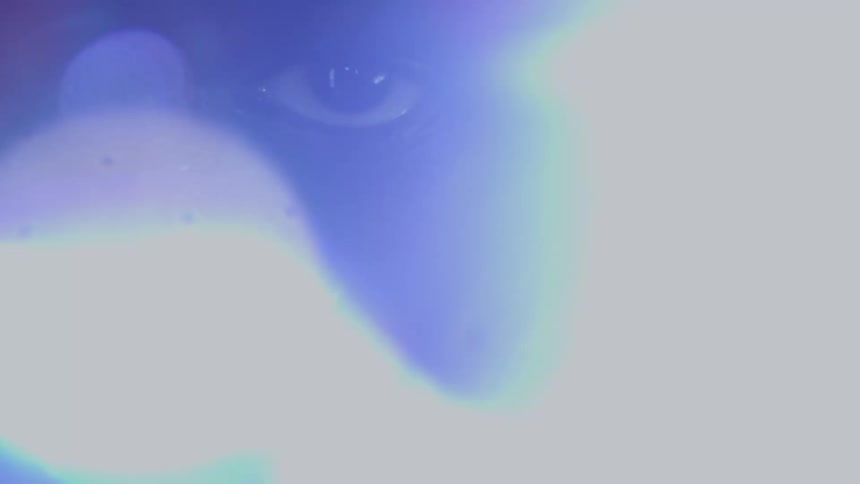 An intense close-up shot captures the determined eye of a boxer staring from behind red gloves as a bright light flare dramatically fills the screen