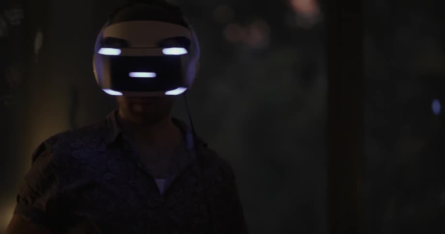 A man stands up looking around with a virtual reality headset