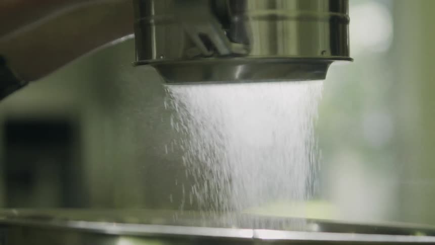 A person sifts flour through a sifter