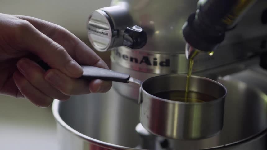 Oil is poured into a cup by a mixer