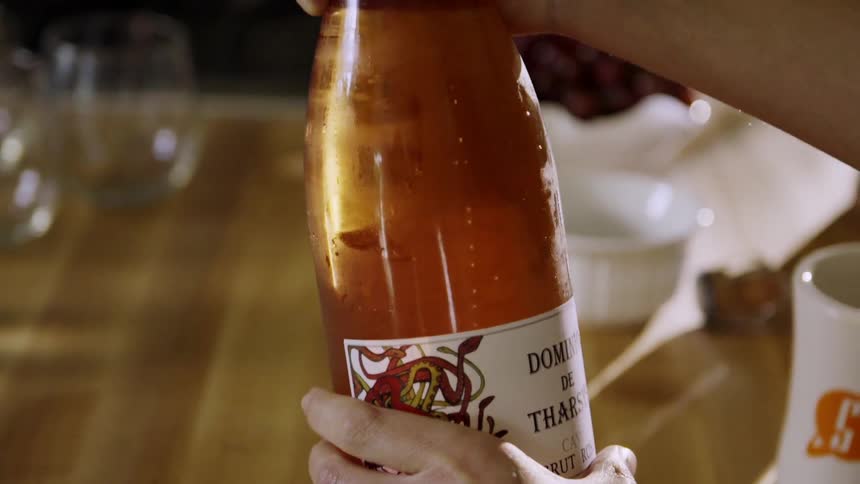 A woman holds a bottle of champagne
