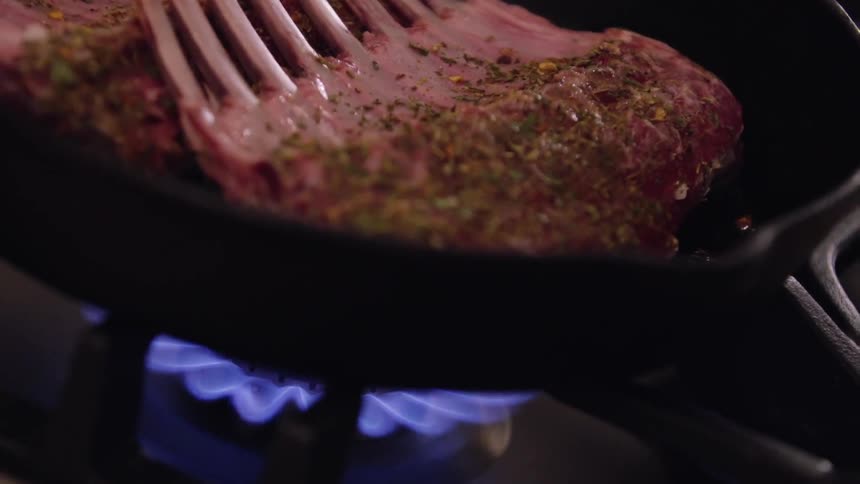 Meat is cooked in a pan on a gas burner