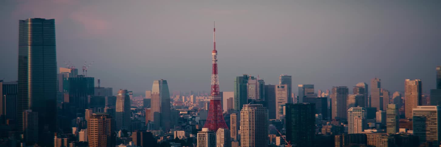 A static wide shot of the iconic Tokyo Tower standing prominently in the bustling city skyline at sunset