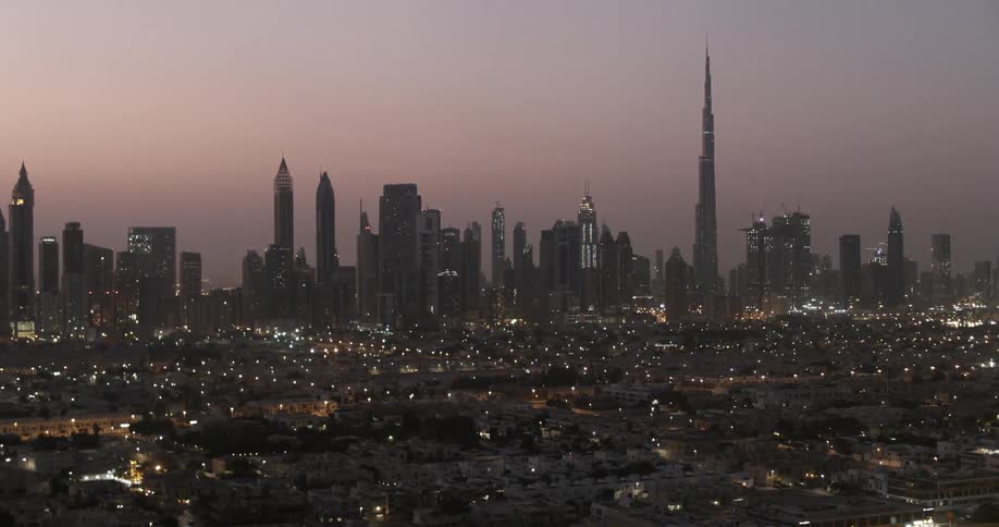 The city is brightly lit with very tall buildings ahead