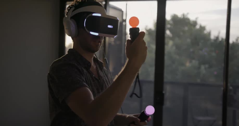 Man waves arms while looking through a virtual machine