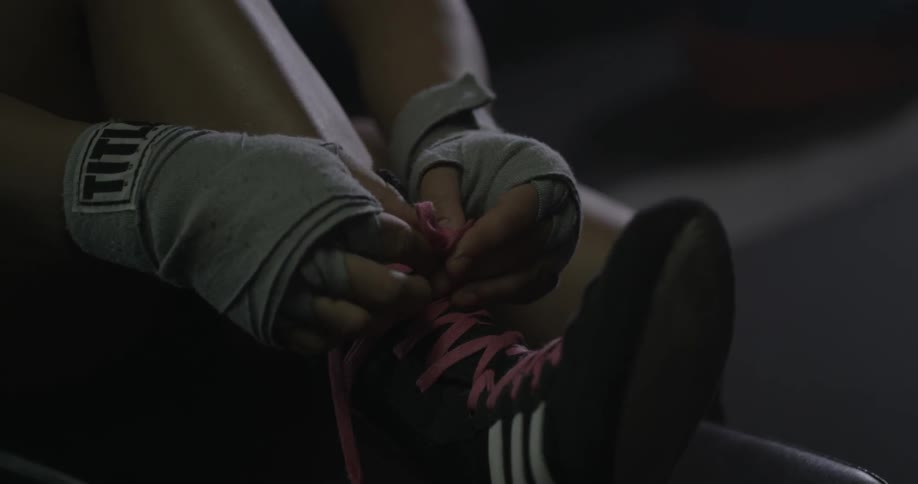 A woman with a ponytail ties her shoes