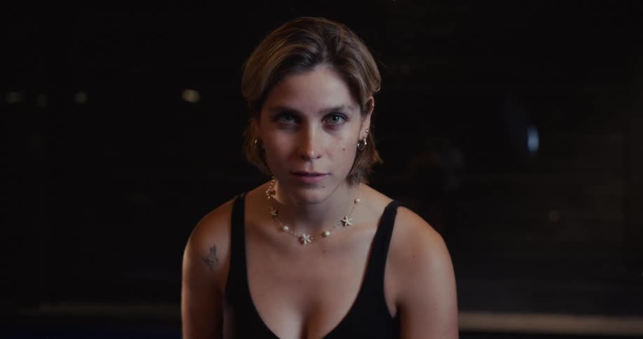 Intense close-up portrait of a serious young woman staring directly into the camera in slow motion