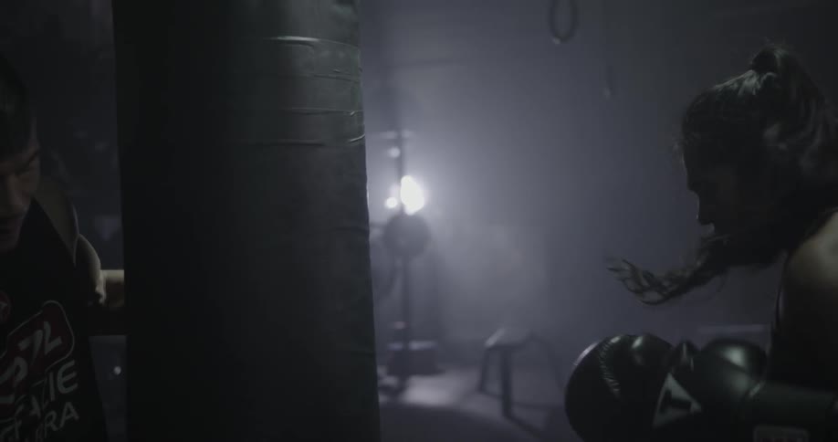 A woman punching a bag inside a gym
