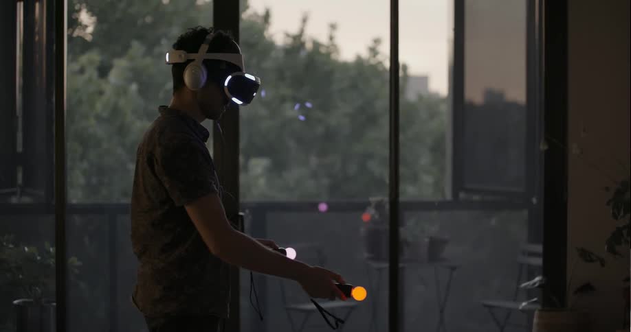 A man is playing a virtual reality game in his living room