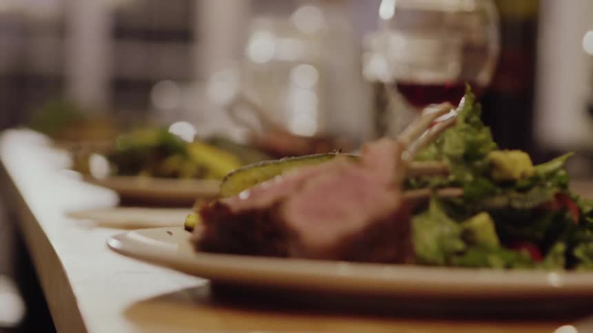 Plates of food and wine sit on a dinner table