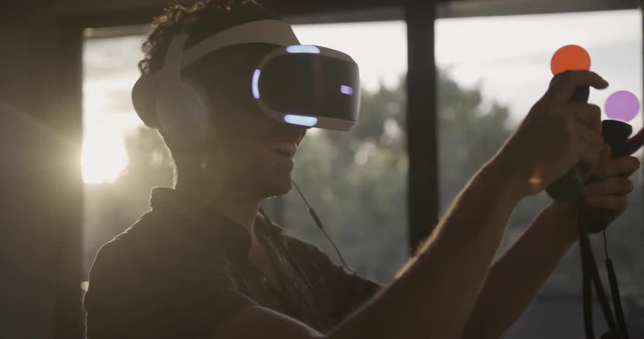 A man smiles and looks around while using a virtual reality headset