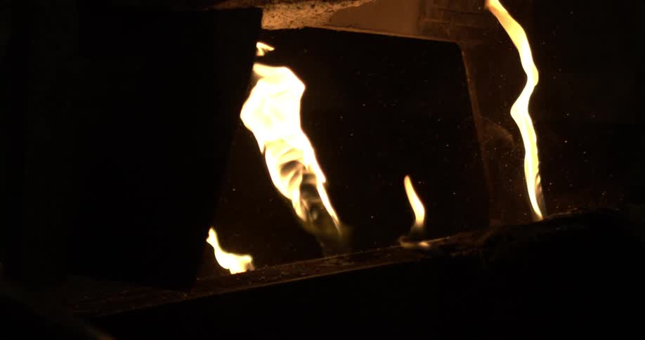 Mesmerizing slow-motion footage of bright yellow flames dancing inside an industrial furnace