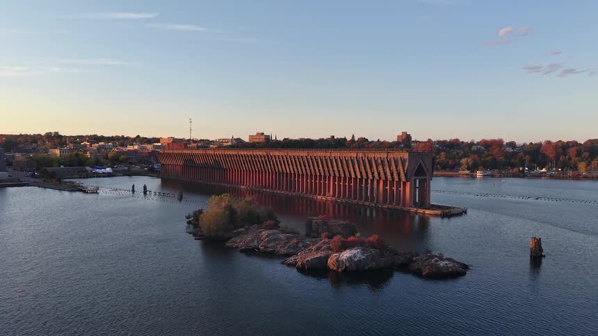 A static aerial view of the historic ore dock in a harbor, glowing in the warm light of an autumn sunrise