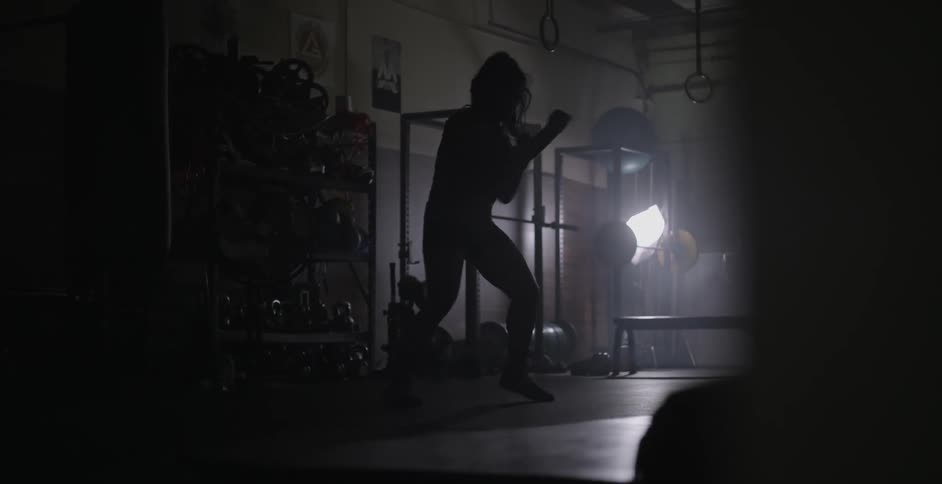 A female athlete is shadow boxing in a gym
