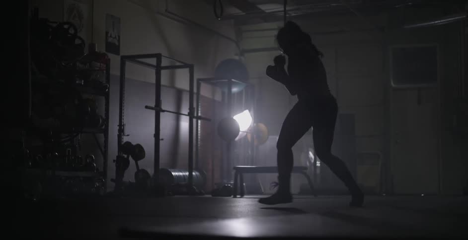 Woman shadow boxing in a dark area indoors