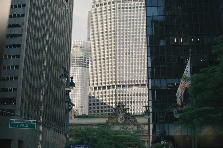 A slow tilt up from a busy New York City street reveals the iconic Grand Central Terminal and the towering MetLife Building behind it