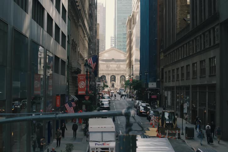 High angle slow pan of a bustling street near Pershing Square in New York City, ending on the reflection of the cityscape in a modern glass building