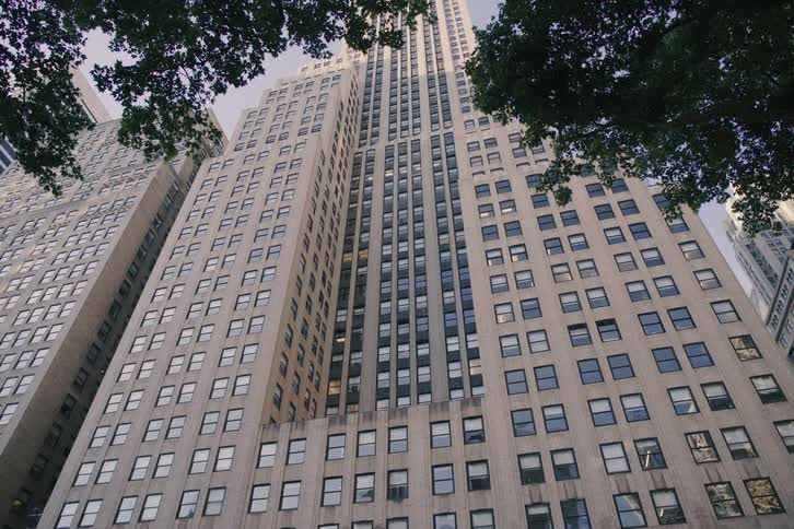 A slow, low-angle tilt-up reveals the immense scale of a classic Art Deco skyscraper in New York City