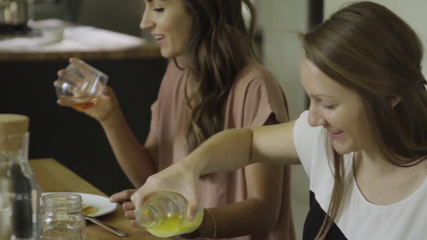 Two women sit at a table eating a meal