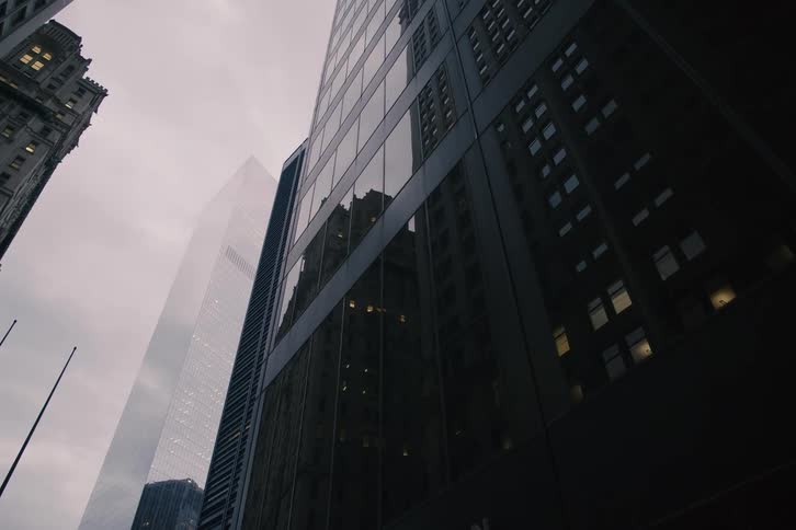 A slow dolly shot reveals the Brown Brothers Harriman building amongst towering skyscrapers in New York City's financial district