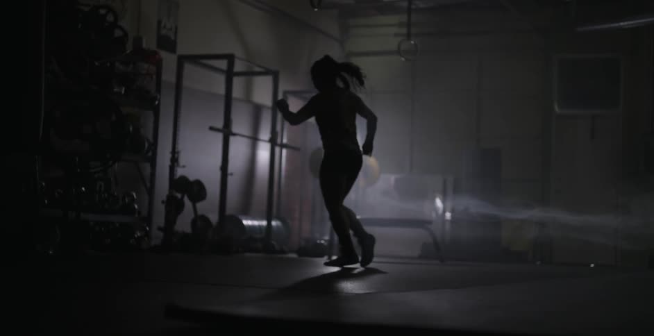 A female athlete is practicing footwork in a gym