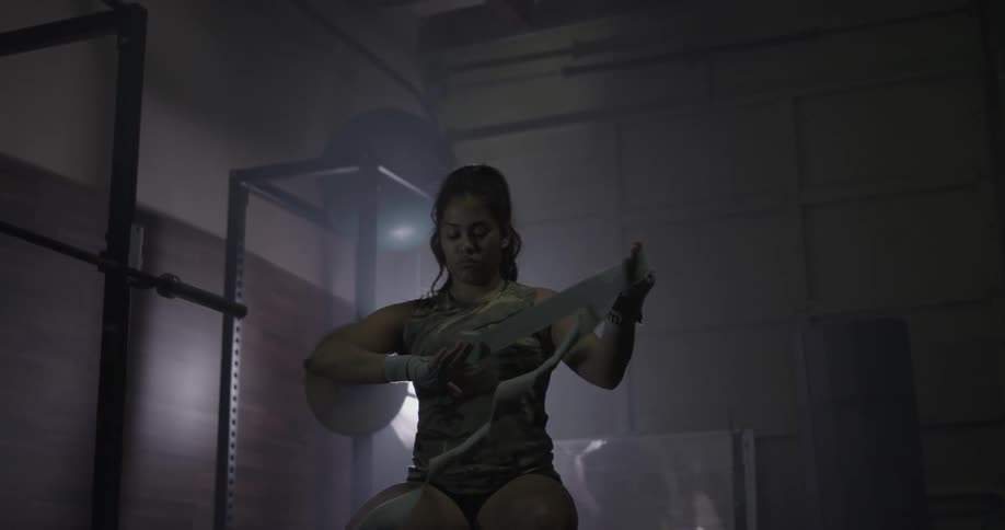 A female boxer is taping up one of her hands