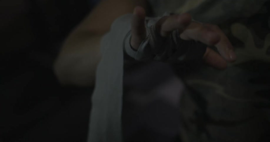 A female boxer is taping up one of her hands