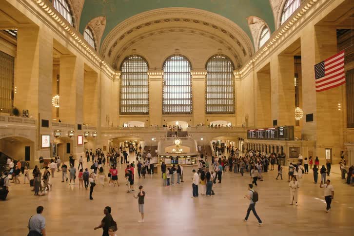 A bustling time-lapse of commuters and tourists walking through the grand main concourse of Grand Central Terminal in New York City