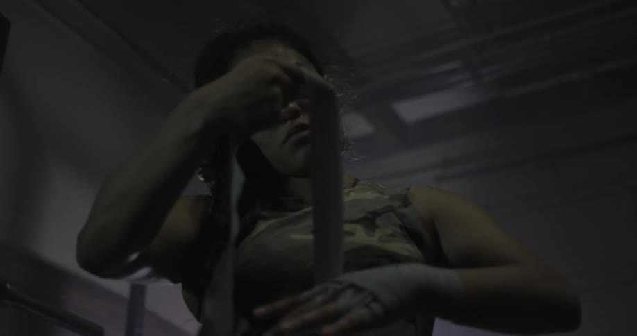 A female fighter is taping up her hand