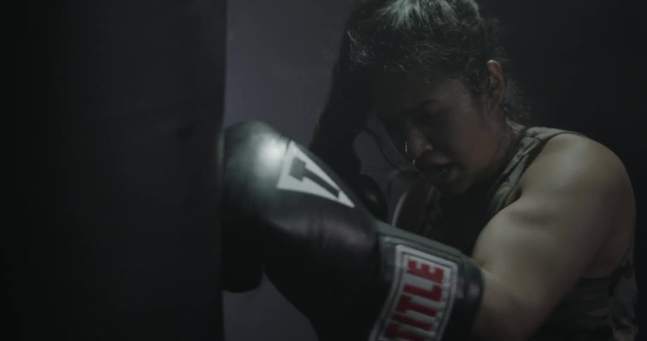 A woman punches a punching bag