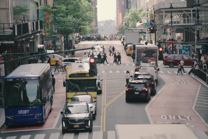 High-angle view of a bustling New York City street with heavy traffic and pedestrians crossing at an intersection