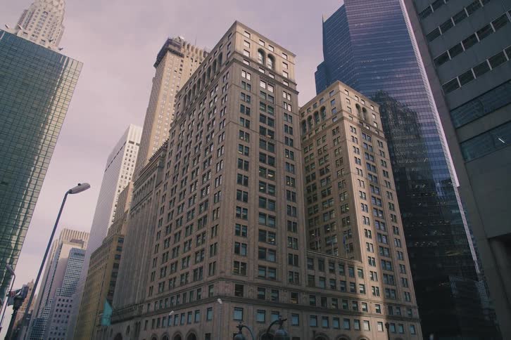 A slow, cinematic dolly shot looks up at the impressive skyscrapers and classic architecture of Midtown Manhattan, New York City
