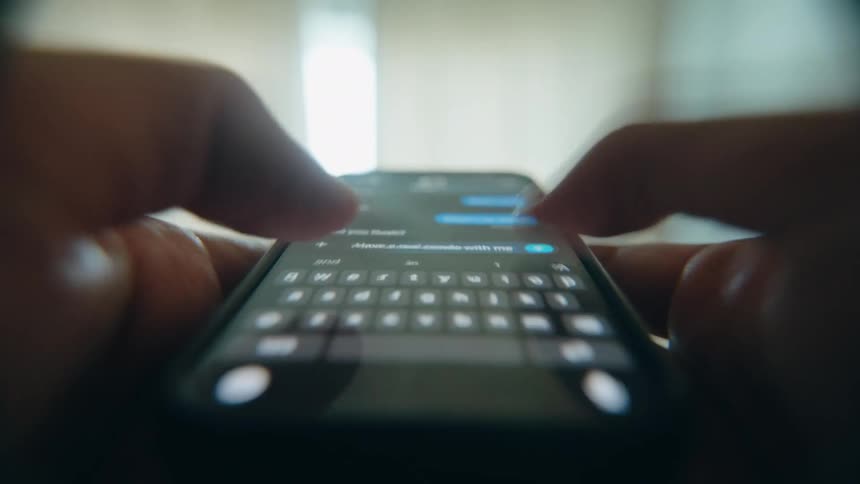 A dramatic, time-lapse, point-of-view shot shows a person rapidly typing messages on their smartphone