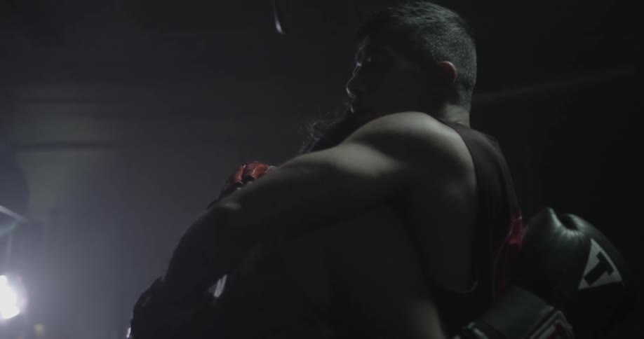 A trainer is hugging a female boxer as they stand in a gym
