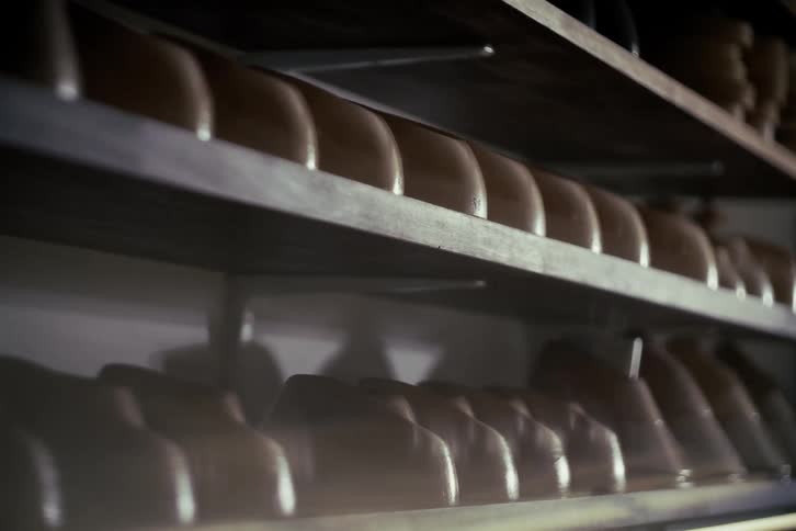 A slow pull back shot reveals rows of shoe lasts lining the shelves of a traditional artisan's workshop