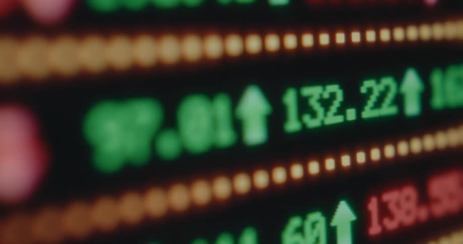 Seamless loop of a close-up financial stock market ticker board with changing numbers and arrows