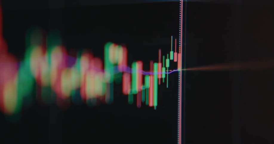 An abstract, out-of-focus close-up of a live cryptocurrency or stock market candlestick chart with flickering red and green bars on a dark screen