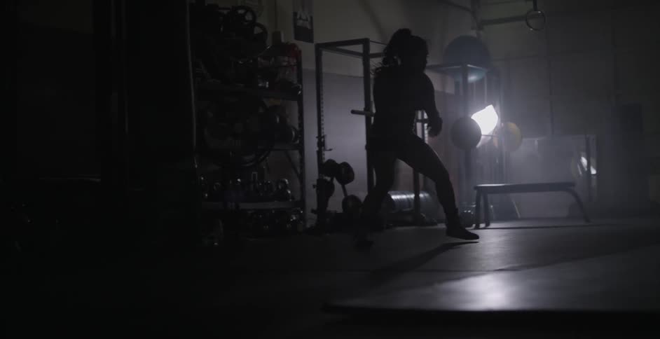 A woman is shadow boxing practicing in a gym