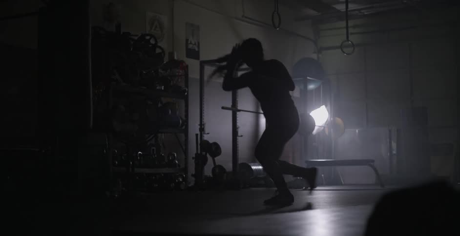 A female athlete is shadow boxing in a gym