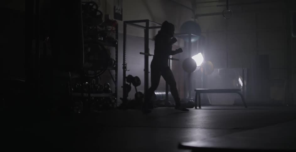 A female athlete is shadow boxing in a gym