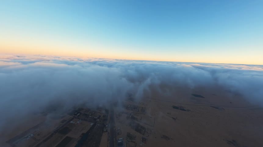 First-person view from a hot air balloon ride floating serenely above a thick blanket of clouds over the desert at sunrise