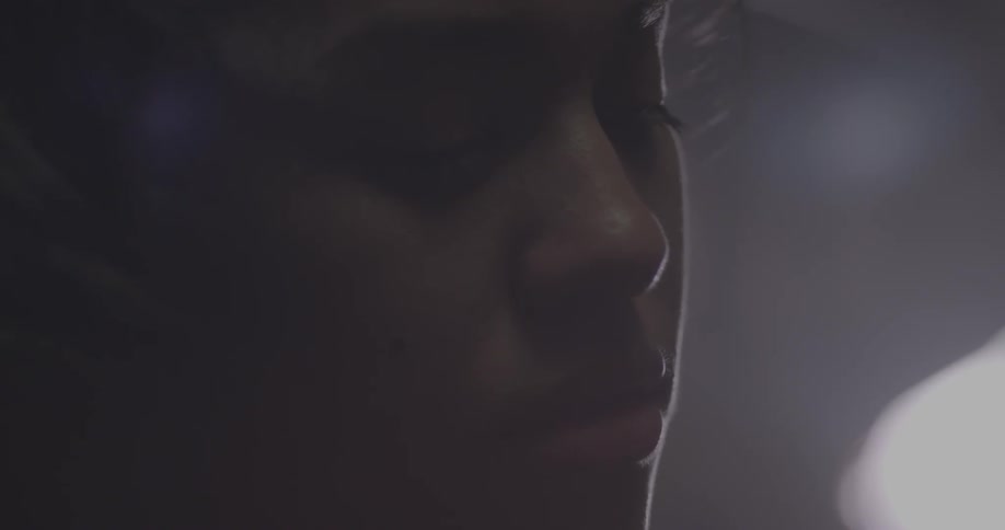 A light shines from behind a girl's face