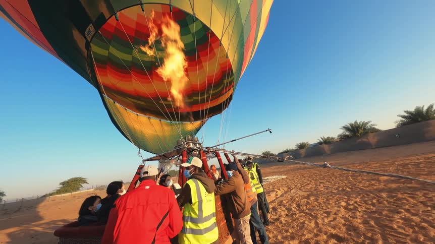 Slow-motion view from the basket of a hot air balloon being inflated with a powerful flame in the desert
