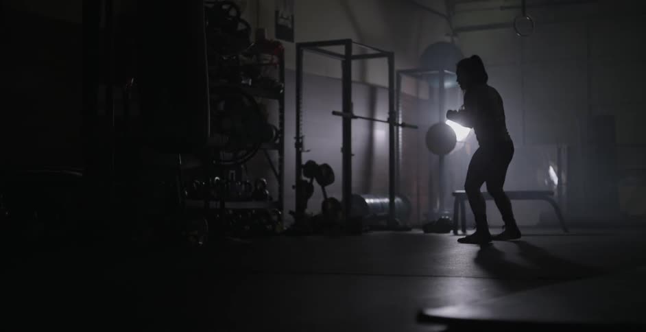 A woman is punching in a gym shadowboxing for practice
