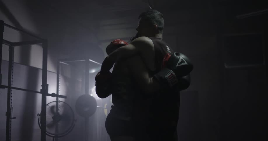 A woman and man hug after sparring