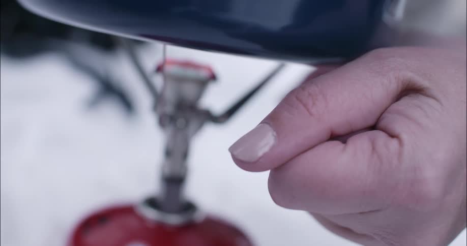 A person is operating a propane grill