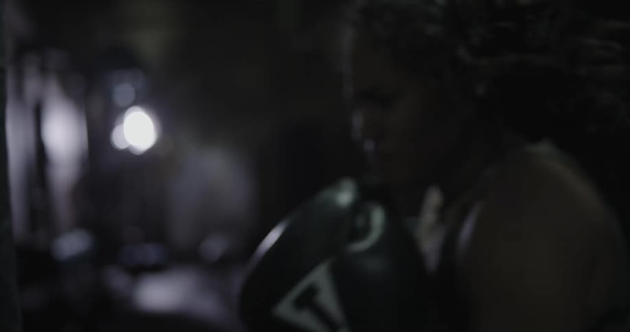 A woman is punching a heavy bag very fast