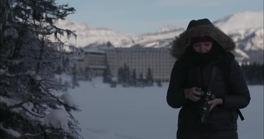 A woman bundled up against the cold is holding a camera