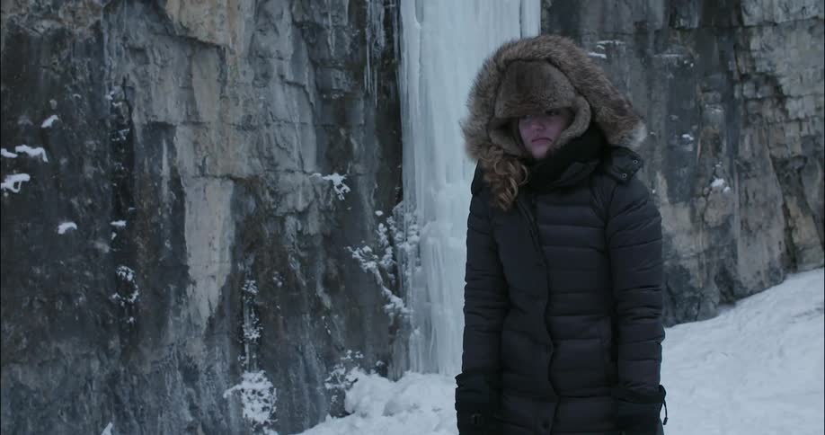 A woman jumps around outside from the cold