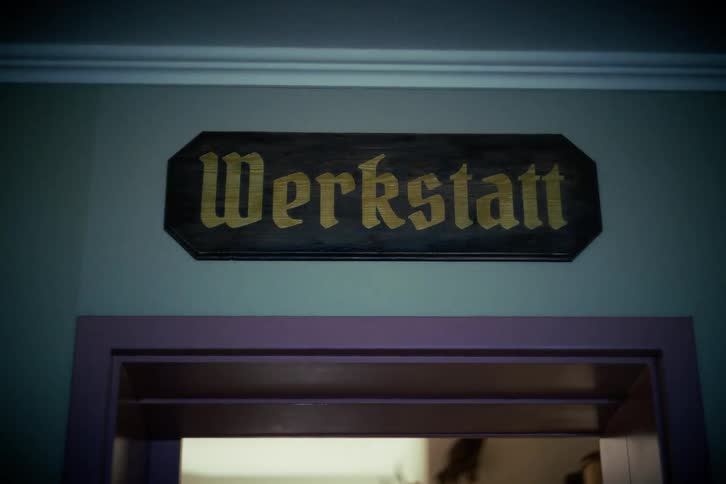 A wooden sign with the word 'Werkstatt,' German for workshop, hangs over a doorway